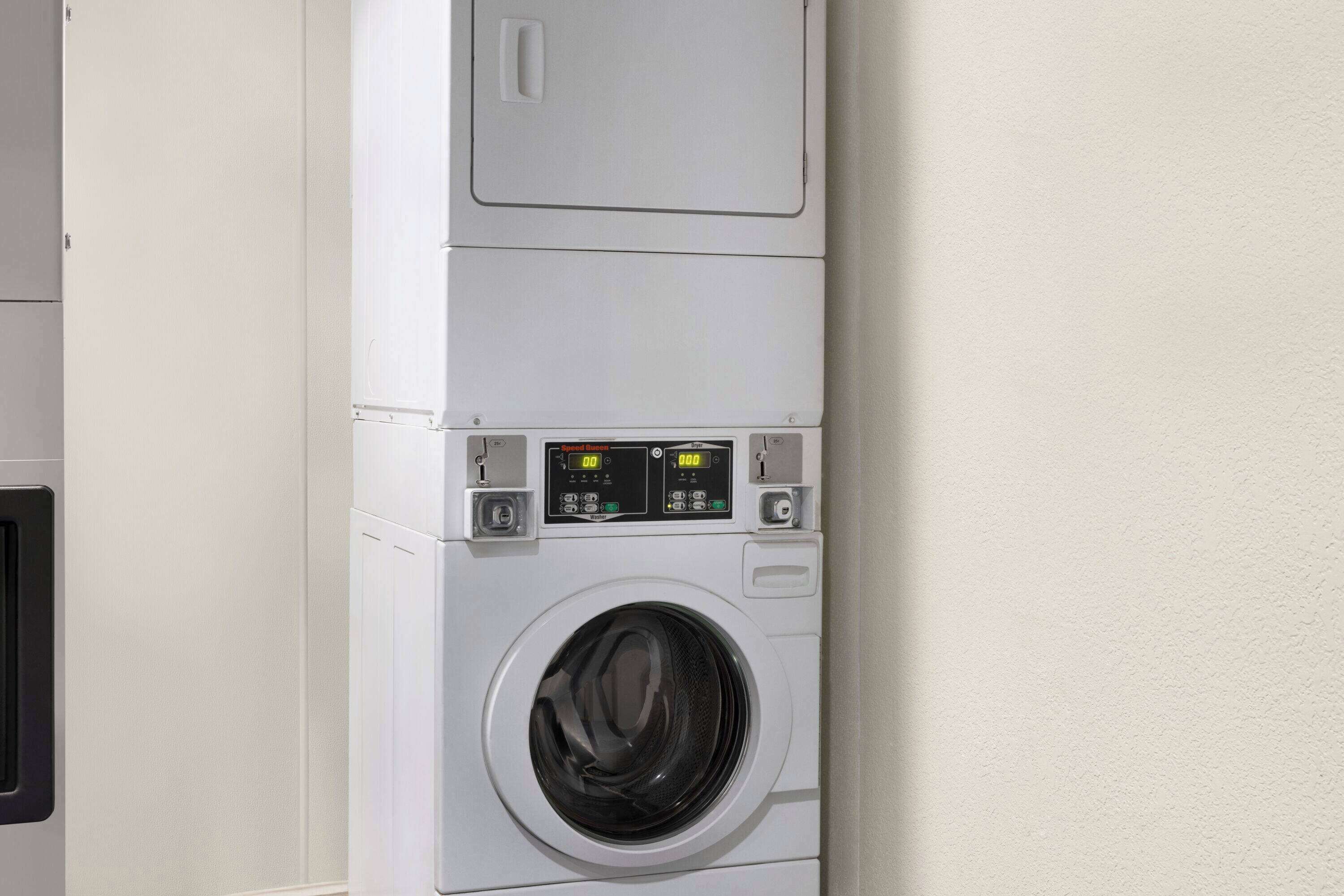A front-loading washing machine with a digital display and control panel.