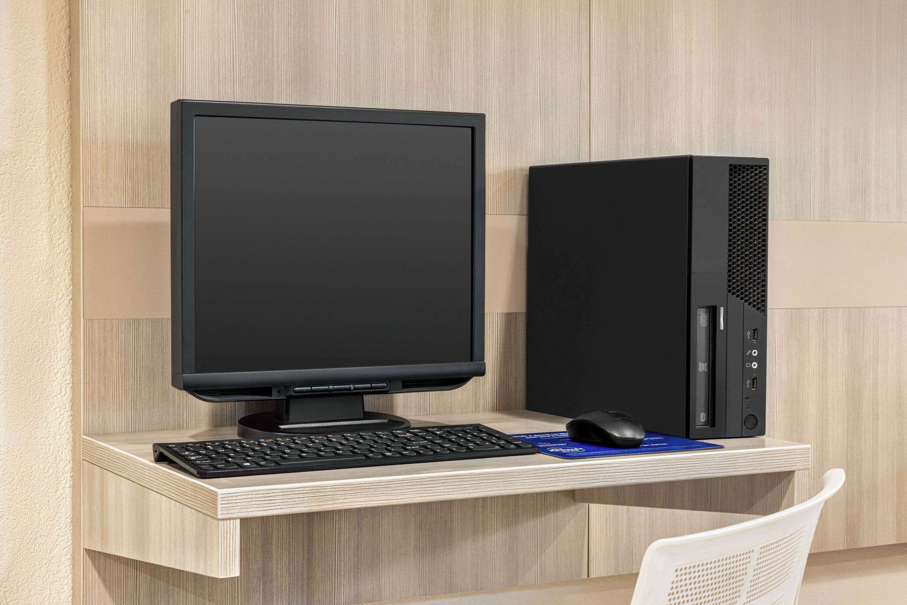 Een moderne werkplek met een bureaubcomputer, toetsenbord en muis op een houten bureau.
