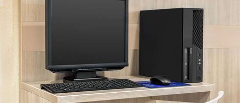 Een moderne werkplek met een bureaubcomputer, toetsenbord en muis op een houten bureau.