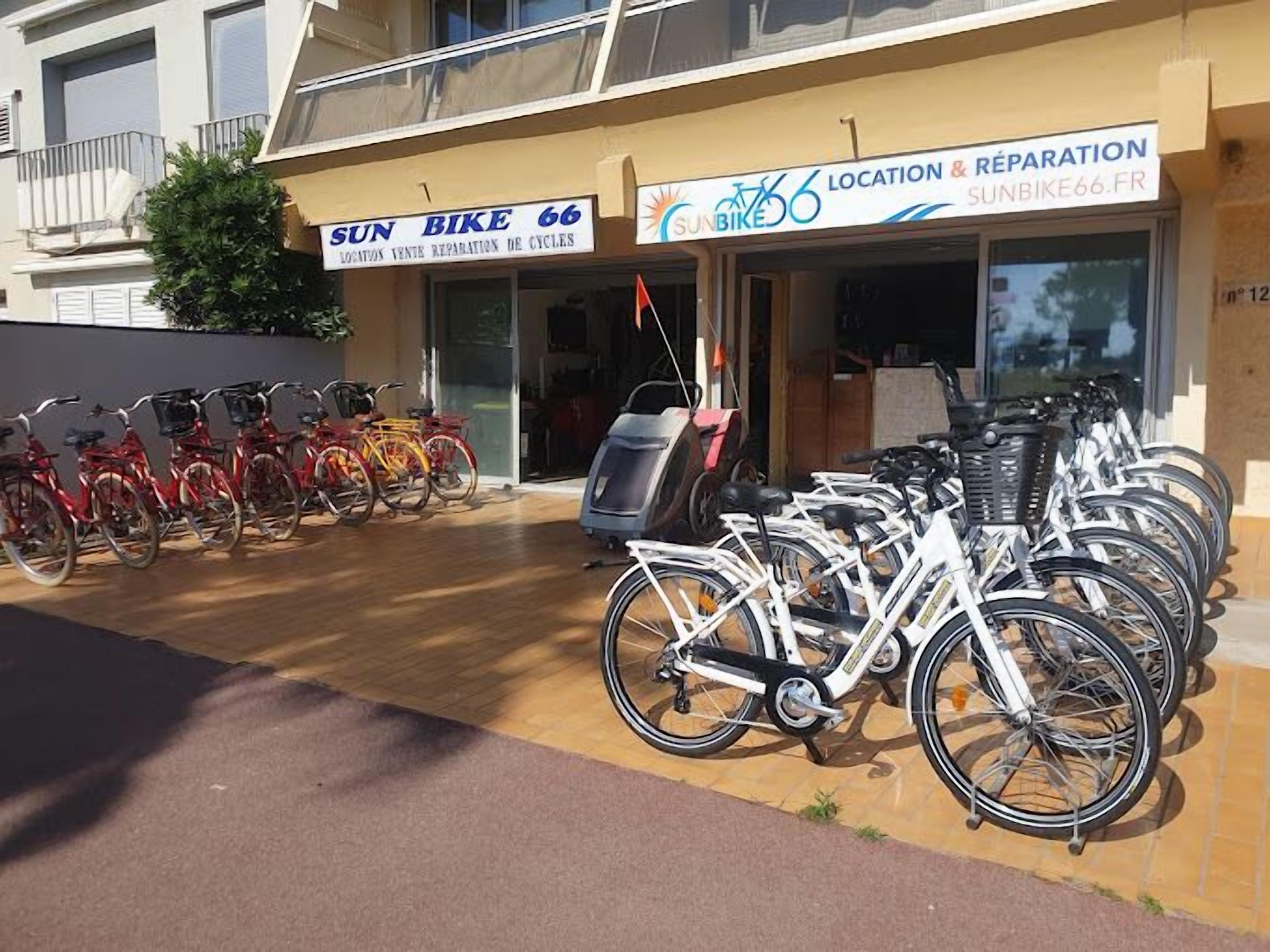Una tienda de reparación de bicicletas con varias bicicletas estacionadas afuera.