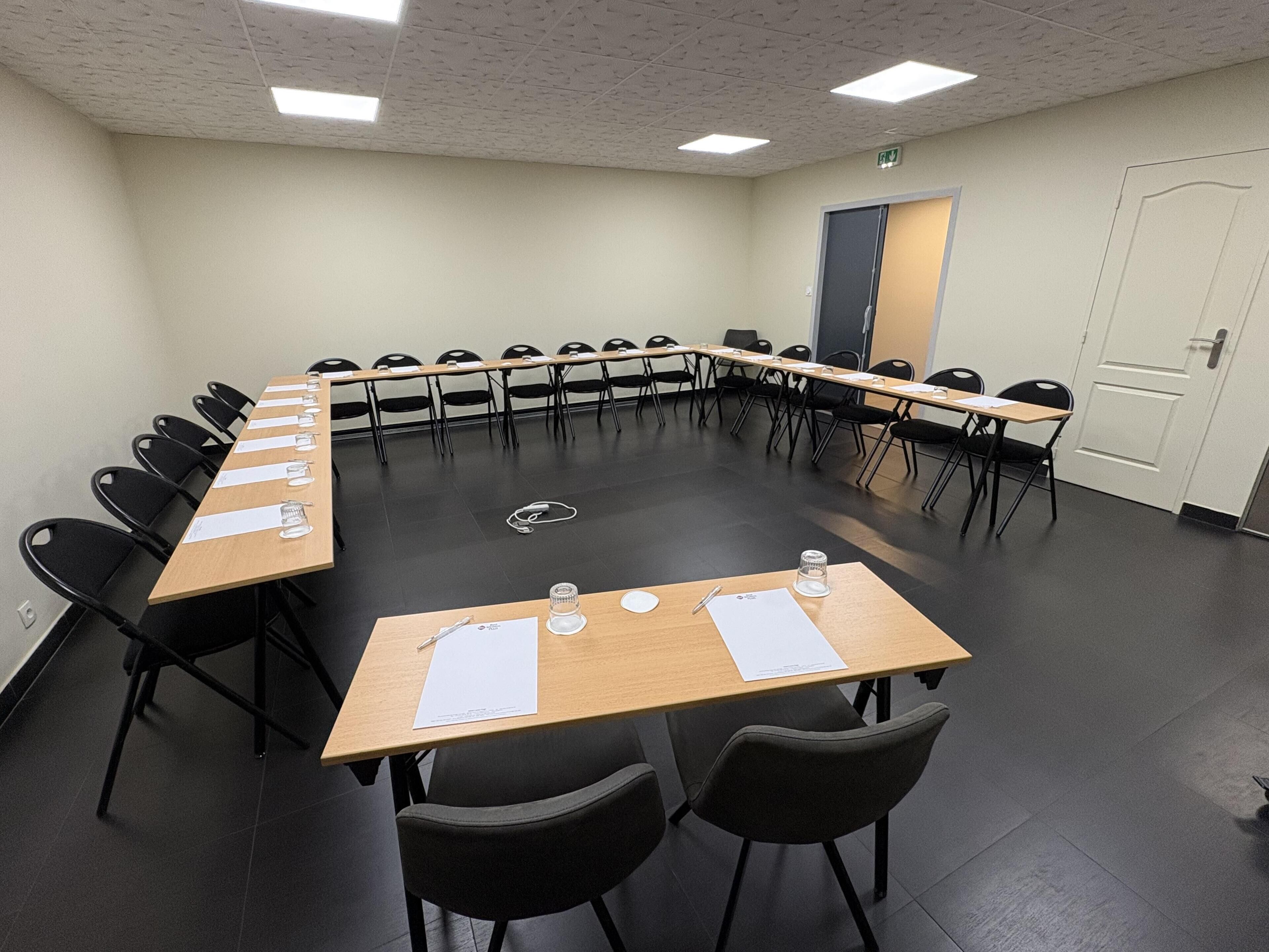 A conference room with a long table, chairs, and a door.
