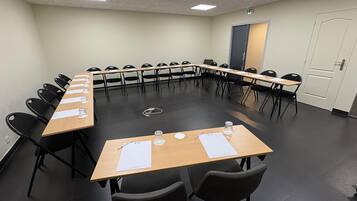 A conference room with a long table, chairs, and a door.
