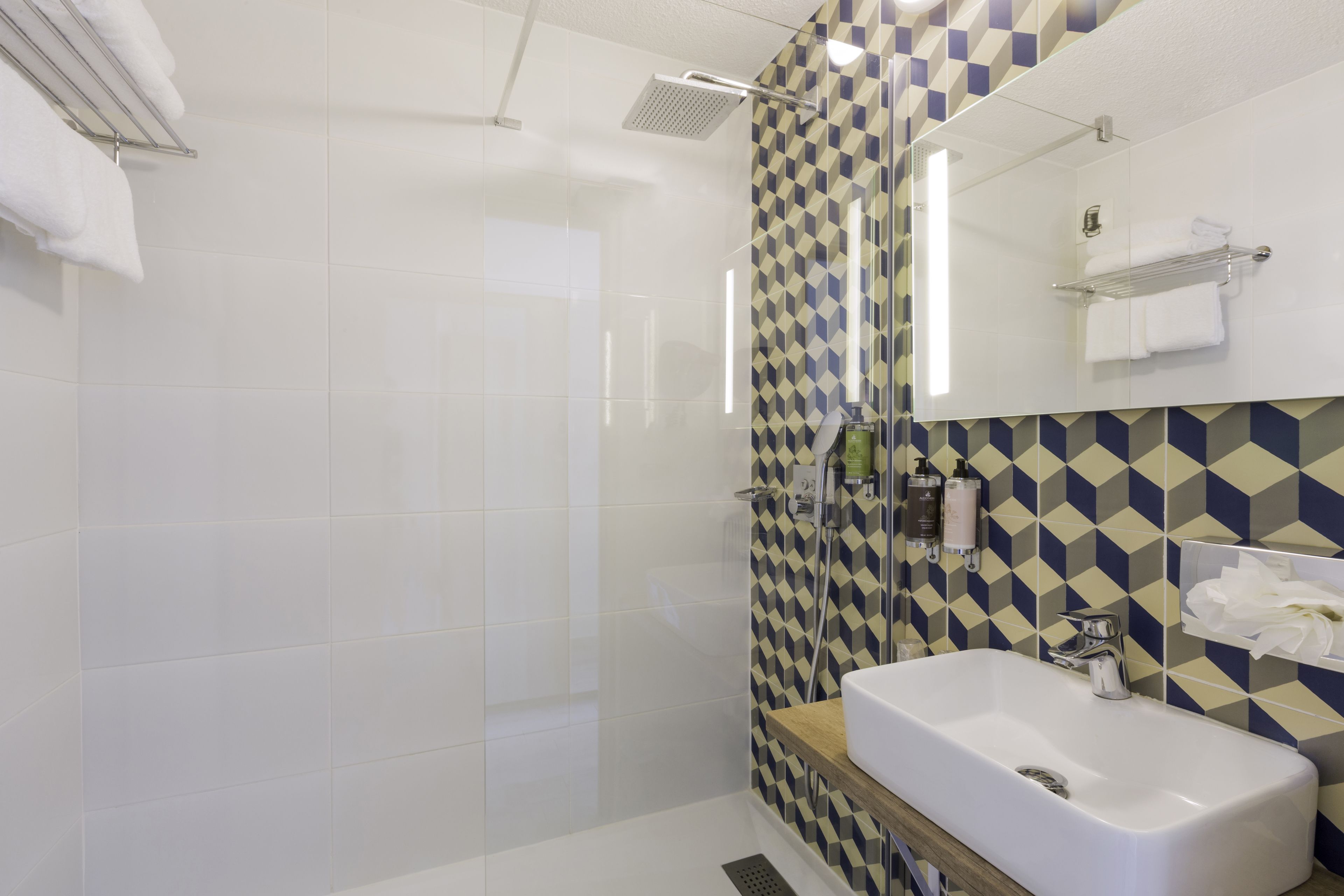 Une salle de bain moderne avec une douche, un lavabo et un miroir.