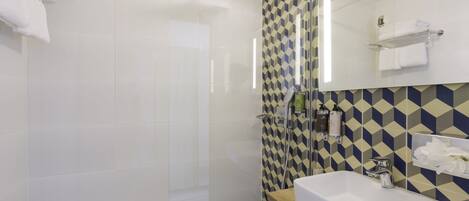 Ein modernes Badezimmer mit Dusche, Waschbecken und Spiegel.
