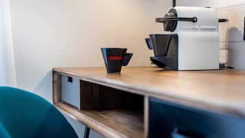 Et moderne køkken med kaffemaskine, en kop og en træbordplade.