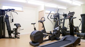 A gym with various exercise equipment including treadmills, stationary bikes, and weight machines.