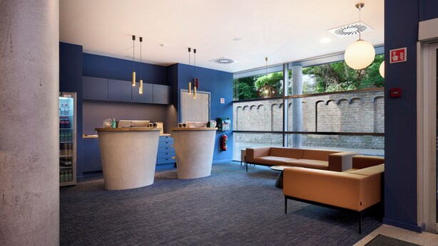 A reception area with a counter, seating, and a view of greenery outside.