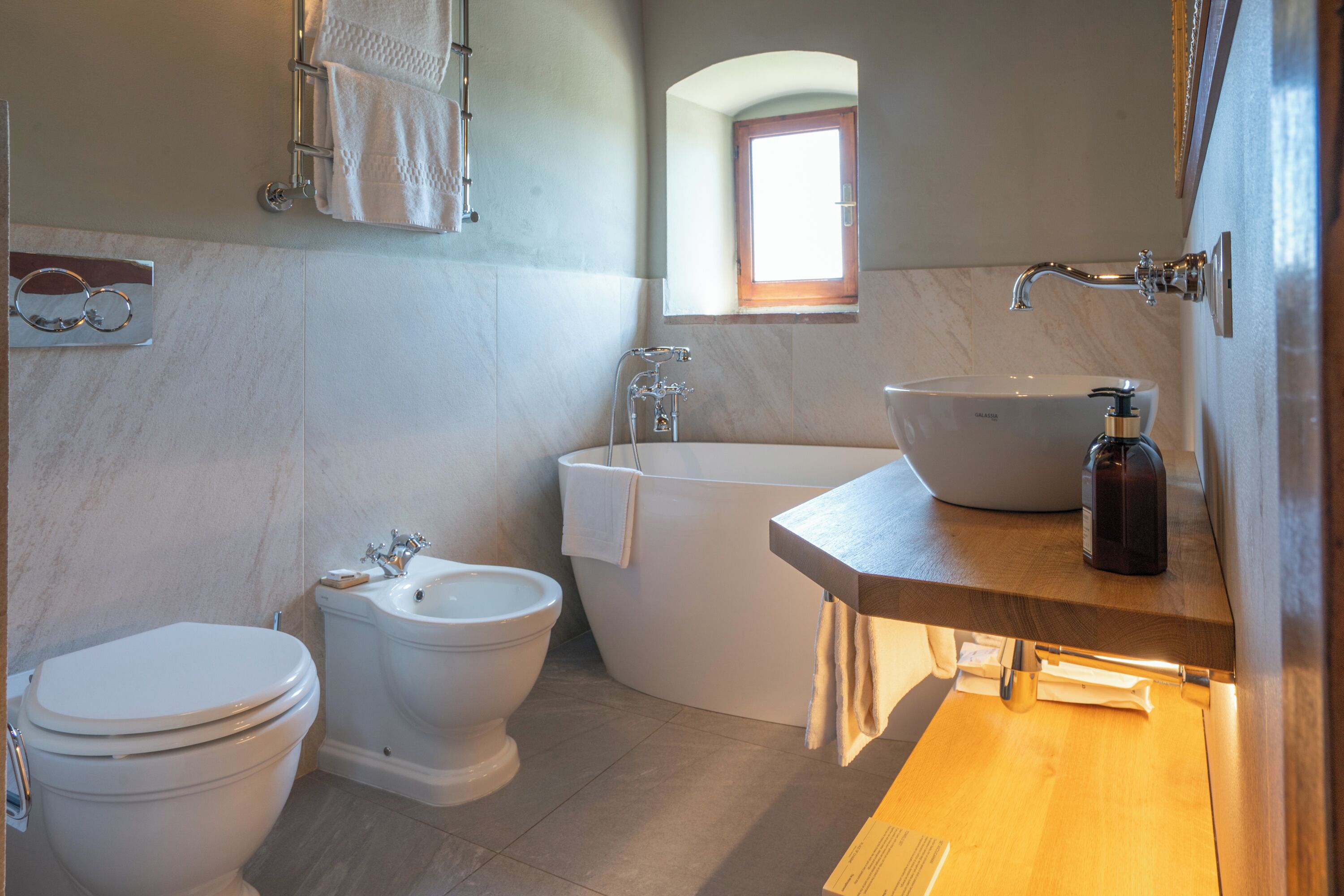 A bathroom with a toilet, bidet, and bathtub.