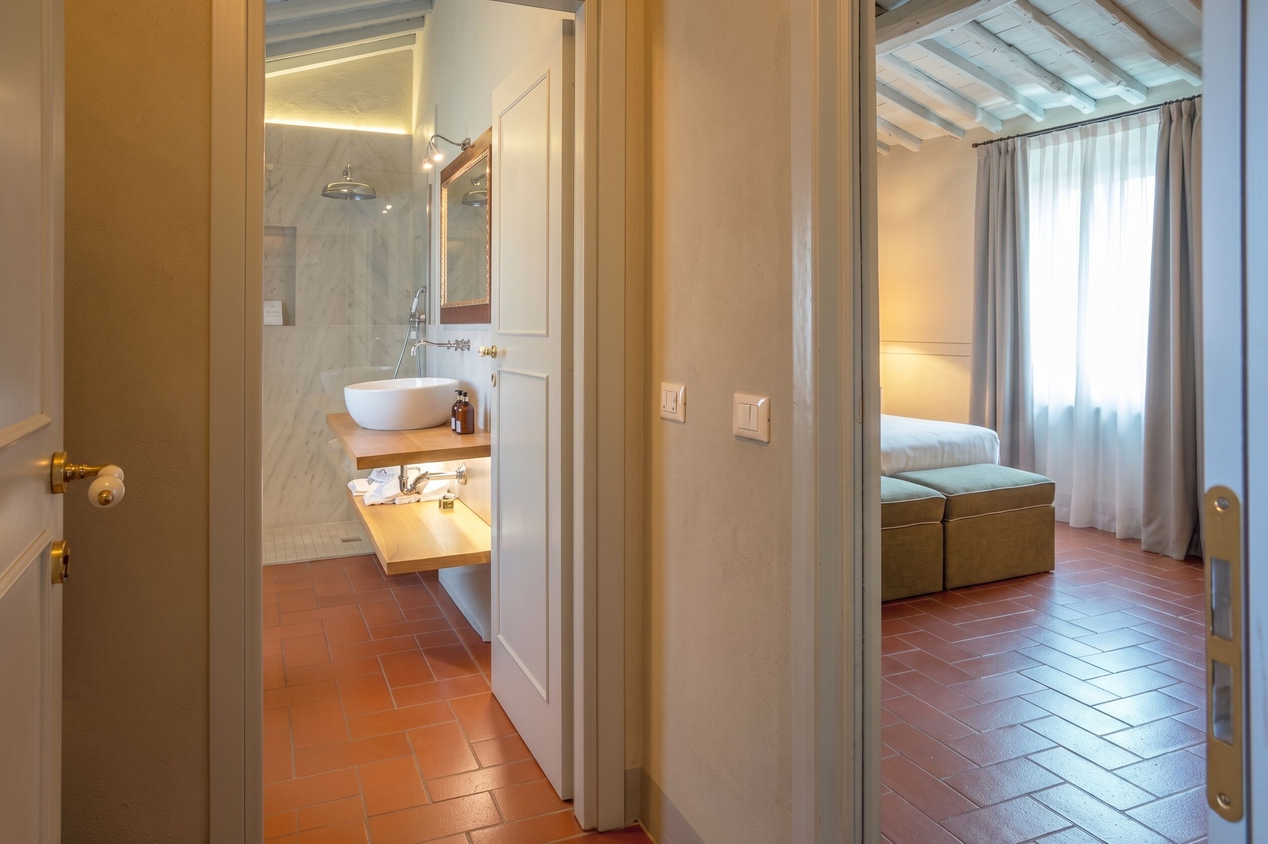 Een hotelbadkamer met een wastafel, spiegel en douche.