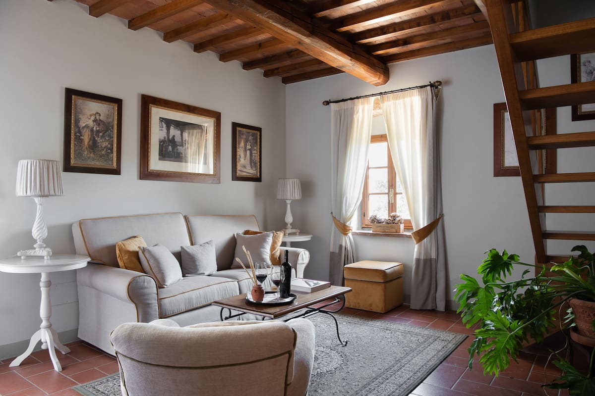 A cozy living room with a sofa, a coffee table, a side table, and a potted plant.