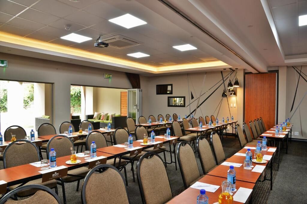 A conference room with long tables, chairs, water bottles, and nameplates.