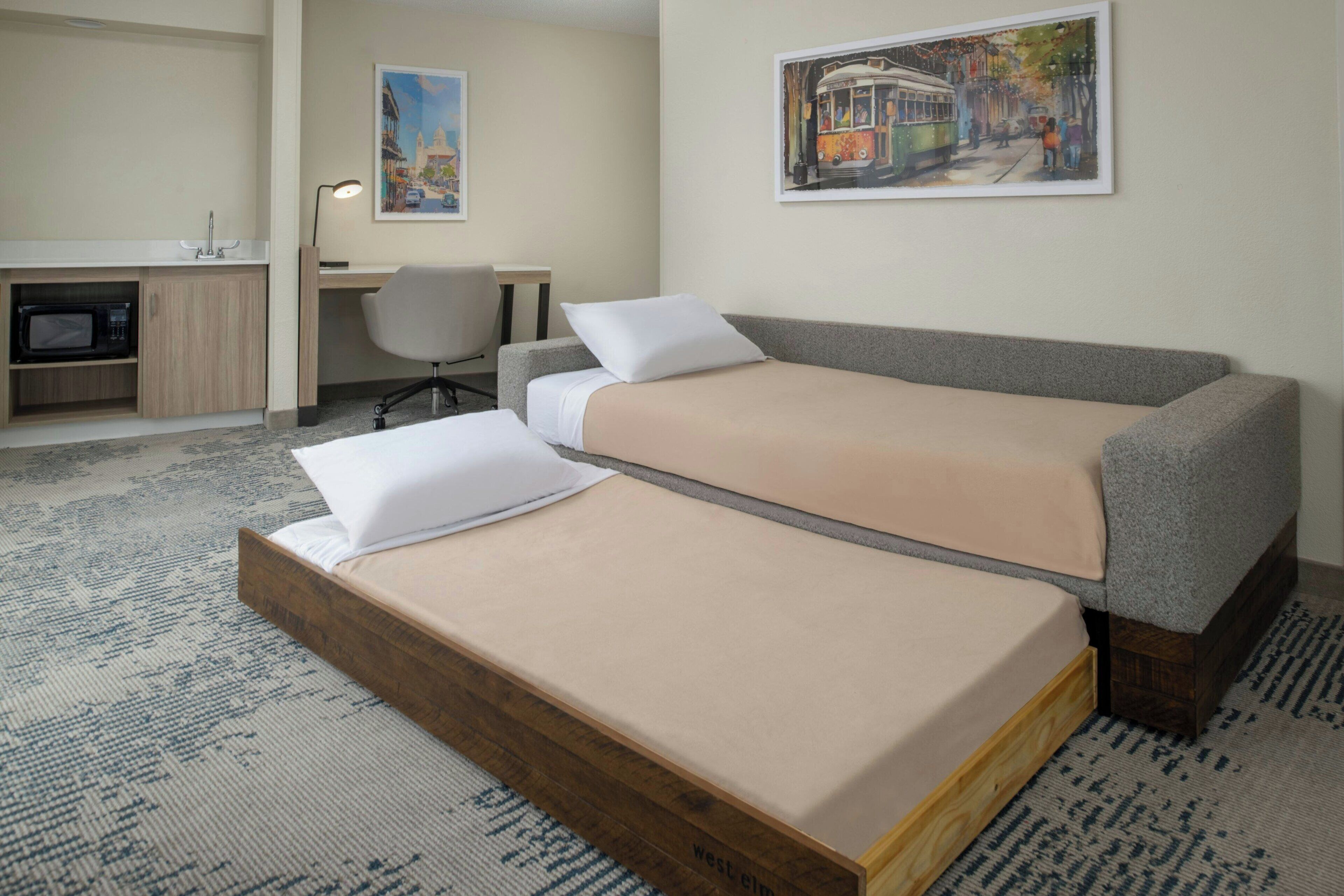 Une chambre d’hôtel équipée d’un lit, d’un bureau, d’une chaise et d’un four à micro-ondes.