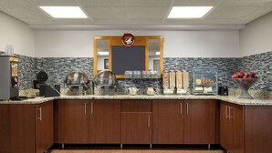 Una cocina moderna con encimeras de granito, electrodomésticos de acero inoxidable y armarios de madera.
