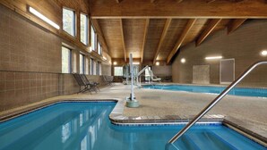 Una piscina interior con techo de madera y paredes de azulejos.