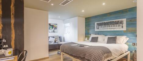 Un dormitorio moderno con cama, mesita de noche e imagen de un piano montado en la pared.