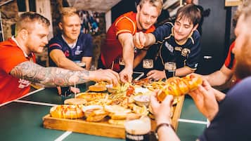A group of people gathered around a table with various food items and drinks.