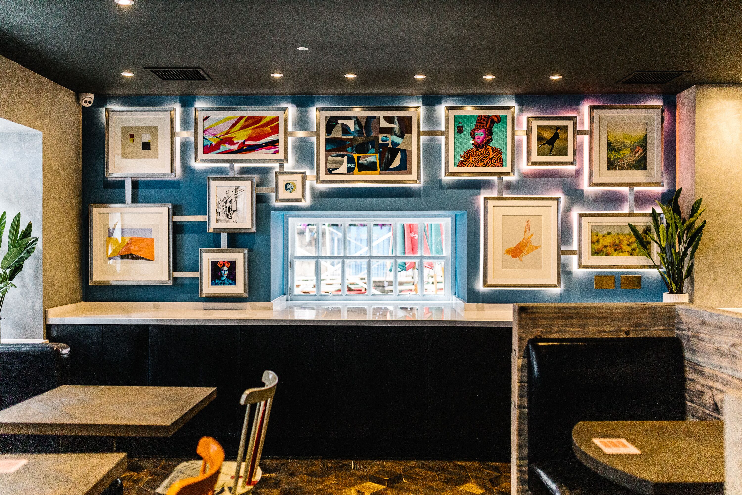 A reception area with framed artwork on the wall, a counter, and seating.