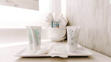 A bathroom with a white sink, a white bath mat, and various NIP FAB skincare products on the counter.