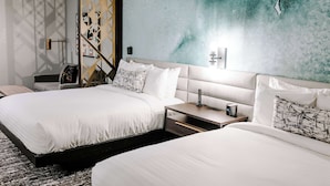 A hotel room with two beds, a nightstand, a lamp, and a wall with a textured design. -  Aiden San Antonio Riverwalk (San Antonio)