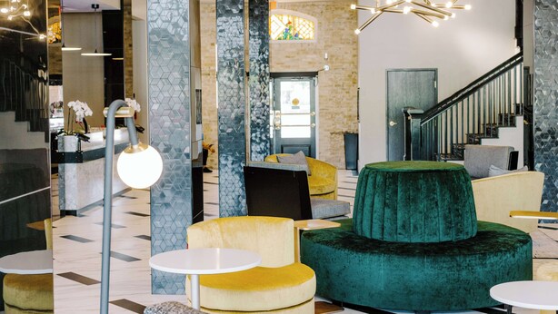 A modern lobby with a staircase, seating areas, and a reception desk. -  Aiden San Antonio Riverwalk (San Antonio)