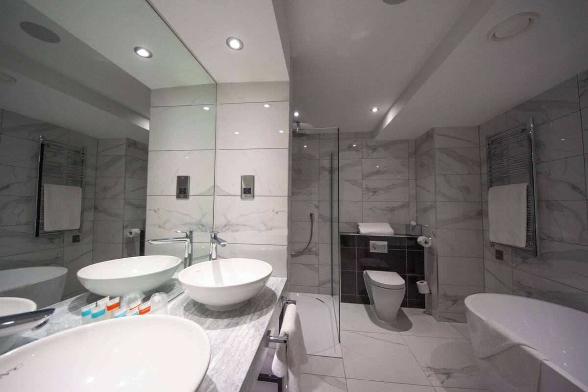 deluxe suite, 1 king bed, non smoking | bathroom | free toiletries, hair dryer, towels