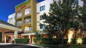 A Courtyard by Marriott hotel with a two-story structure, a covered entrance, and well-maintained landscaping.
