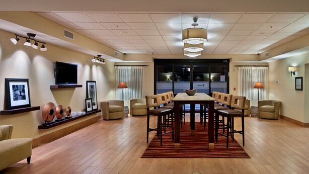 A spacious dining area with a long table, multiple chairs, and a central bowl. - Hampton Inn Phoenix/Anthem (Phoenix)