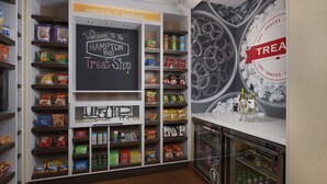A treat shop with shelves stocked with snacks and a chalkboard sign welcoming visitors. - Hampton Inn Phoenix/Anthem (Phoenix)