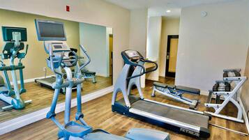 A gym with treadmills, elliptical machines, and weight equipment.