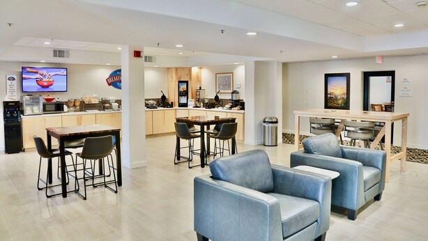 A modern hotel lobby with a dining area, bar, and seating. - Baymont by Wyndham Tucson Airport (Tucson)