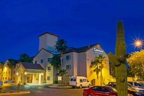 A hotel with a prominent sign for Comfort Inn & Suites, featuring a modern design with a flat roof and a tower-like structure. - Comfort Inn & Suites - Tucson Airport (Tucson)