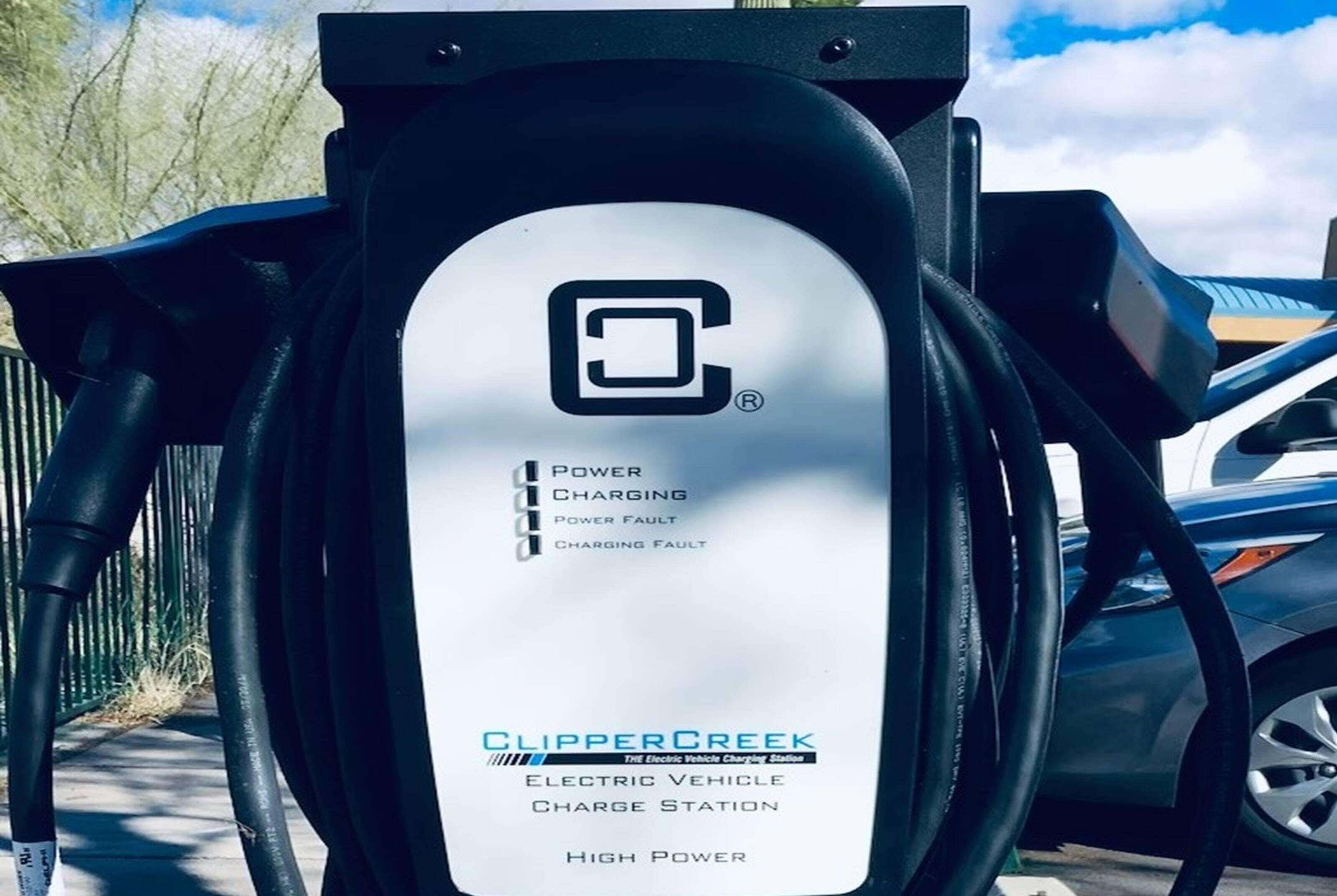 Een laadstation voor elektrische voertuigen met een wit label dat opties voor hoog vermogen en laadstoring aangeeft.