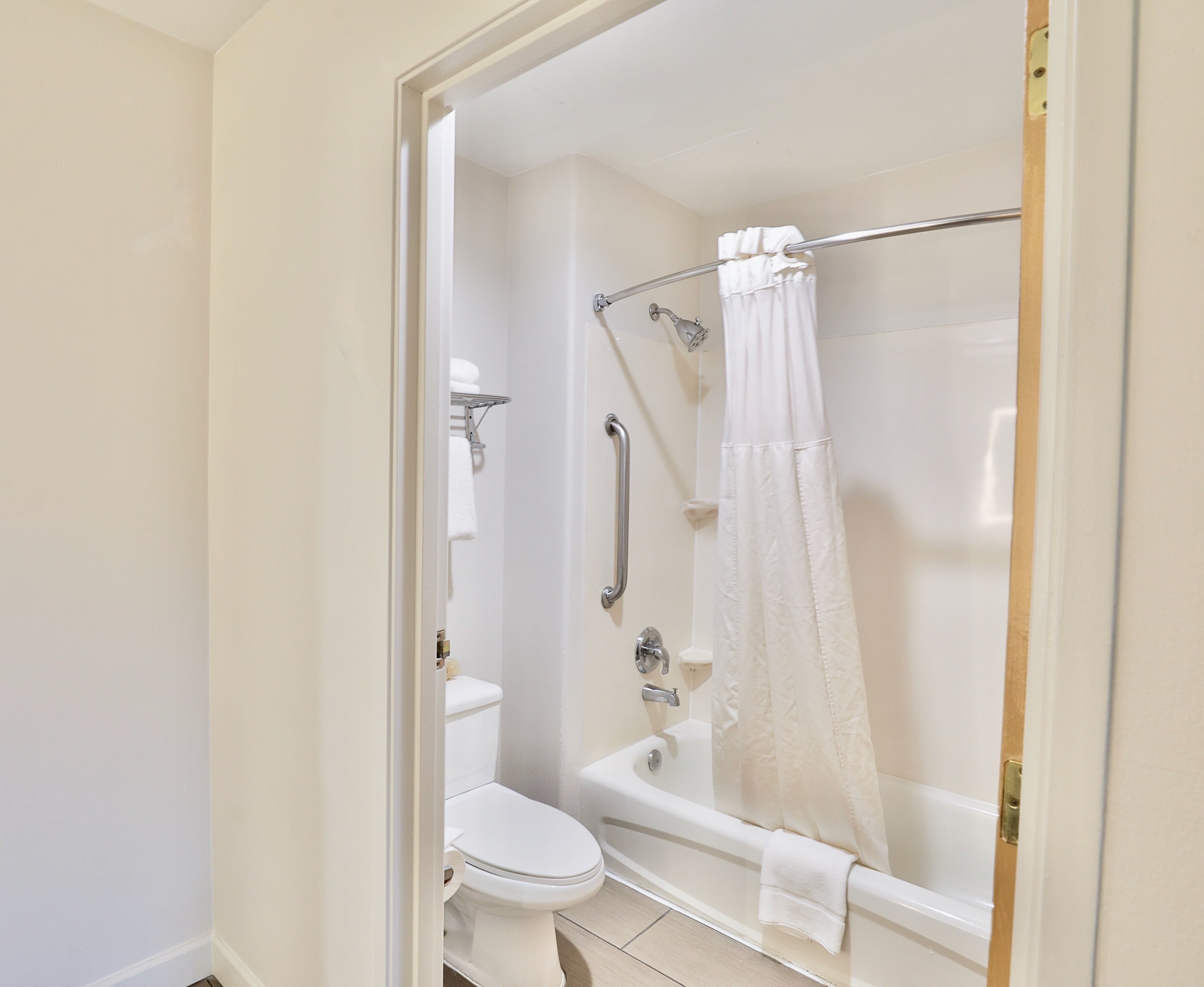 A bathroom with a toilet, a bathtub, and a shower curtain.