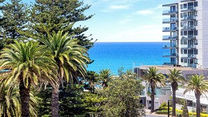 Un hôtel en bord de mer offrant une vue sur l’océan, doté de nombreux balcons et présentant un style architectural moderne.