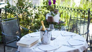 A table set for a meal with a bottle of champagne, glasses, and a menu. - Alla Rocca Hotel (Valsamoggia)