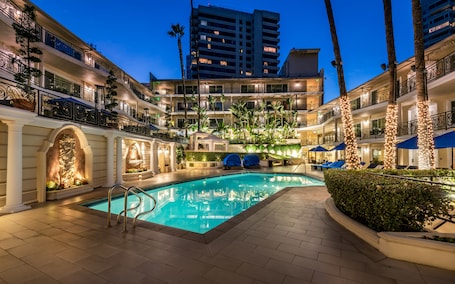 Una piscina al aire libre, camas de piscina gratis, sombrillas