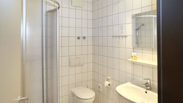 Ein Badezimmer mit Toilette, Waschbecken und Dusche.