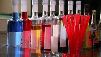 Una barra con varias botellas de alcohol y pajitas rojas.