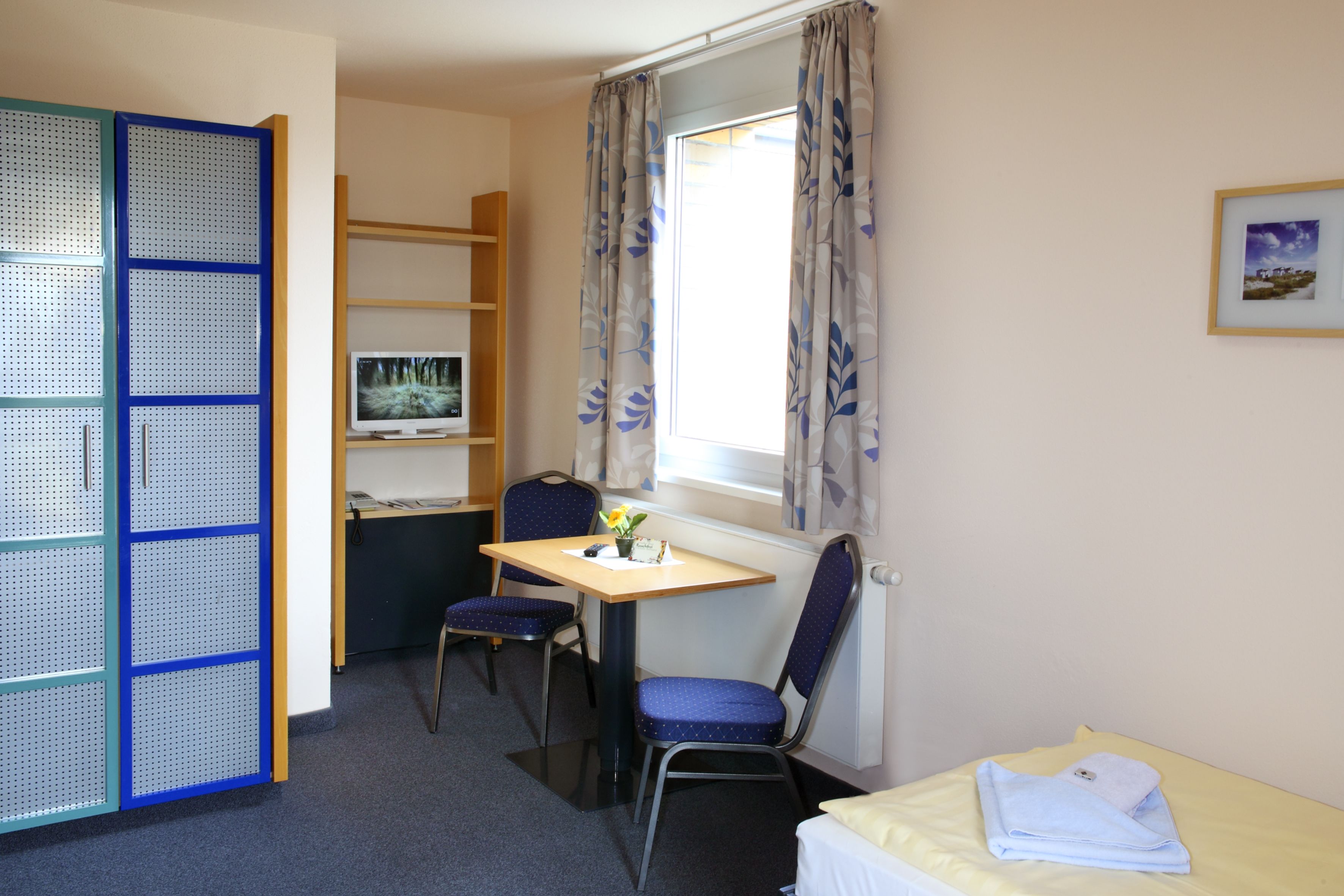A compact room with a desk, chair, and bed.