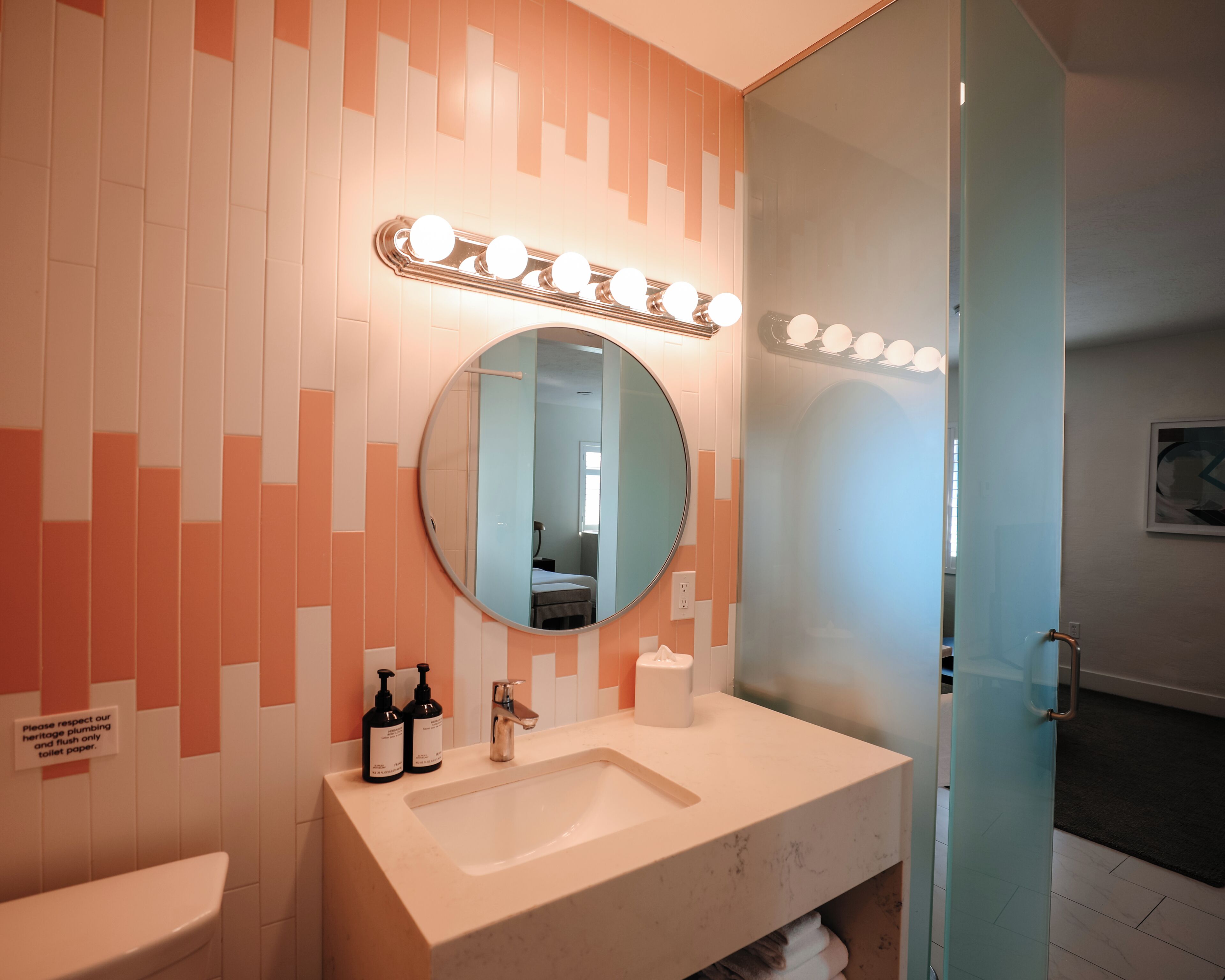 Un baño con lavabo, espejo y artículos de aseo.