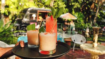Un plateau avec deux boissons, l’une décorée d’une fraise et de feuilles de menthe, et un véhicule en arrière-plan.
