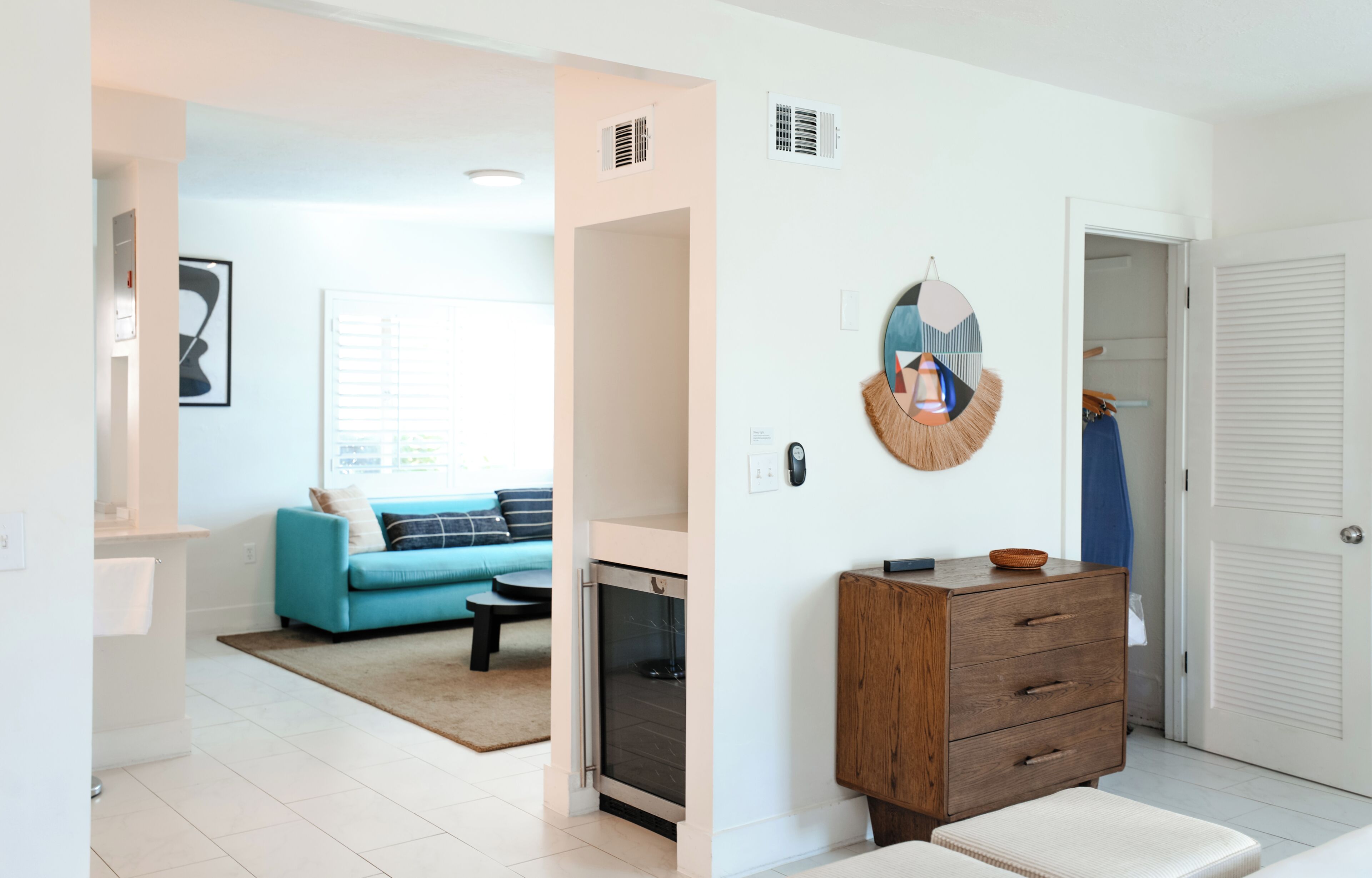 A modern living room with a blue sofa, a fireplace, and a wooden cabinet.