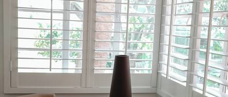 A room with a round table, two chairs, and a vase.