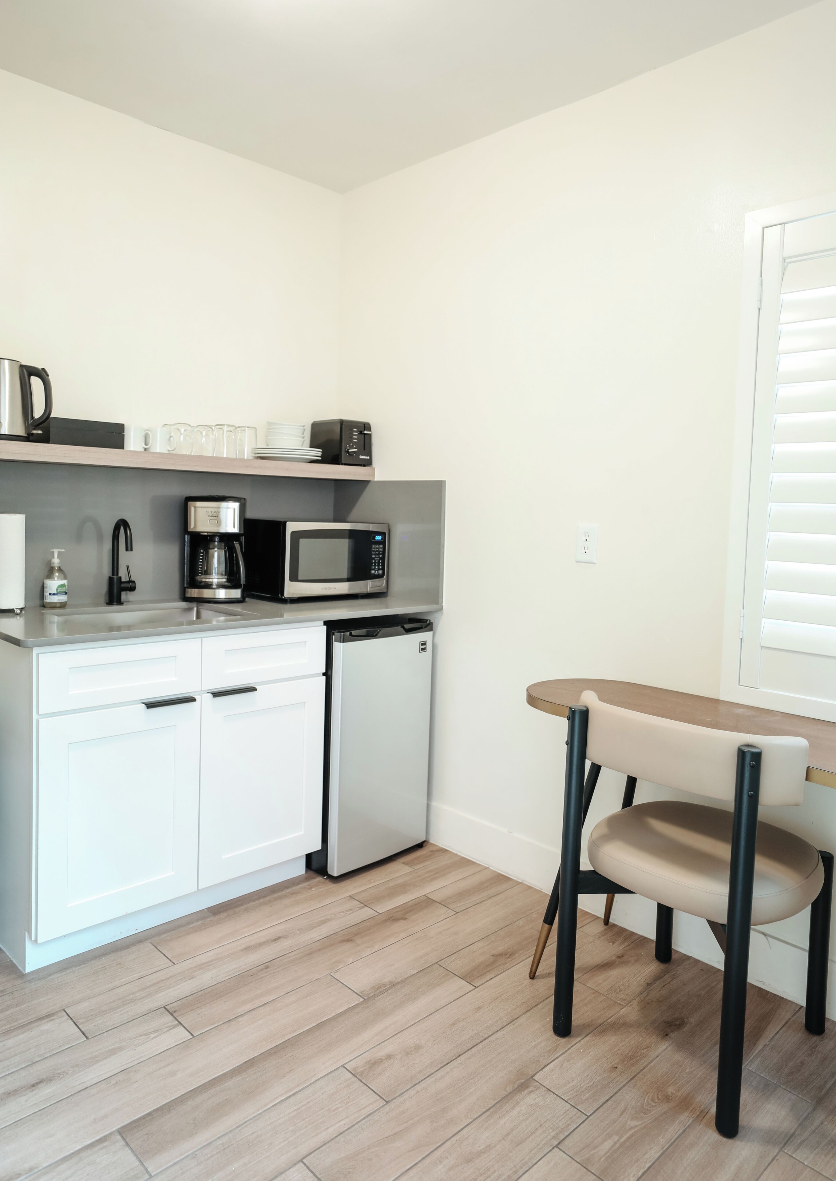 A compact kitchenette with a microwave, coffee maker, and a small refrigerator.