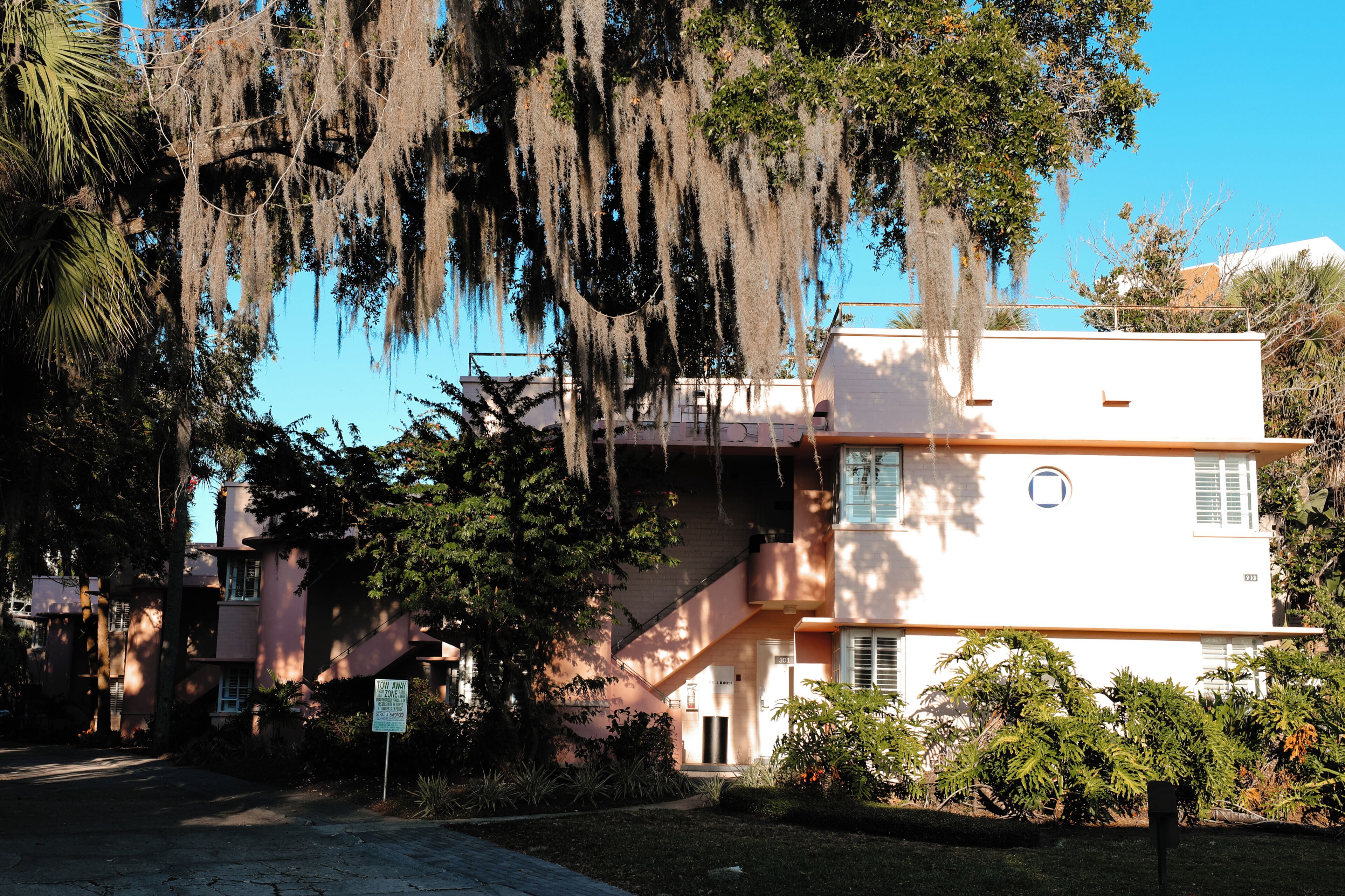 A two-story building with a flat roof and a balcony.
