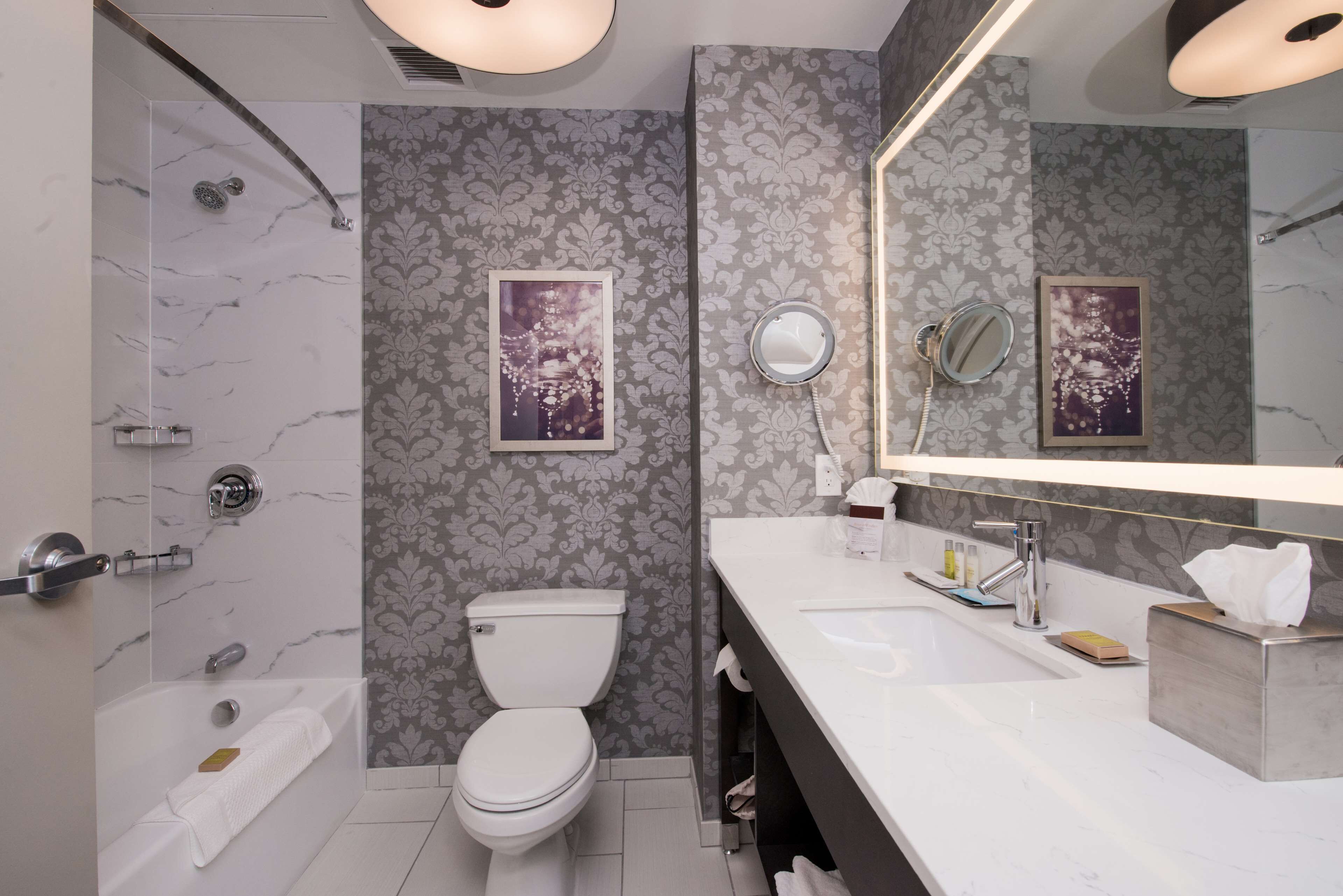 A modern bathroom with a shower, toilet, and vanity.