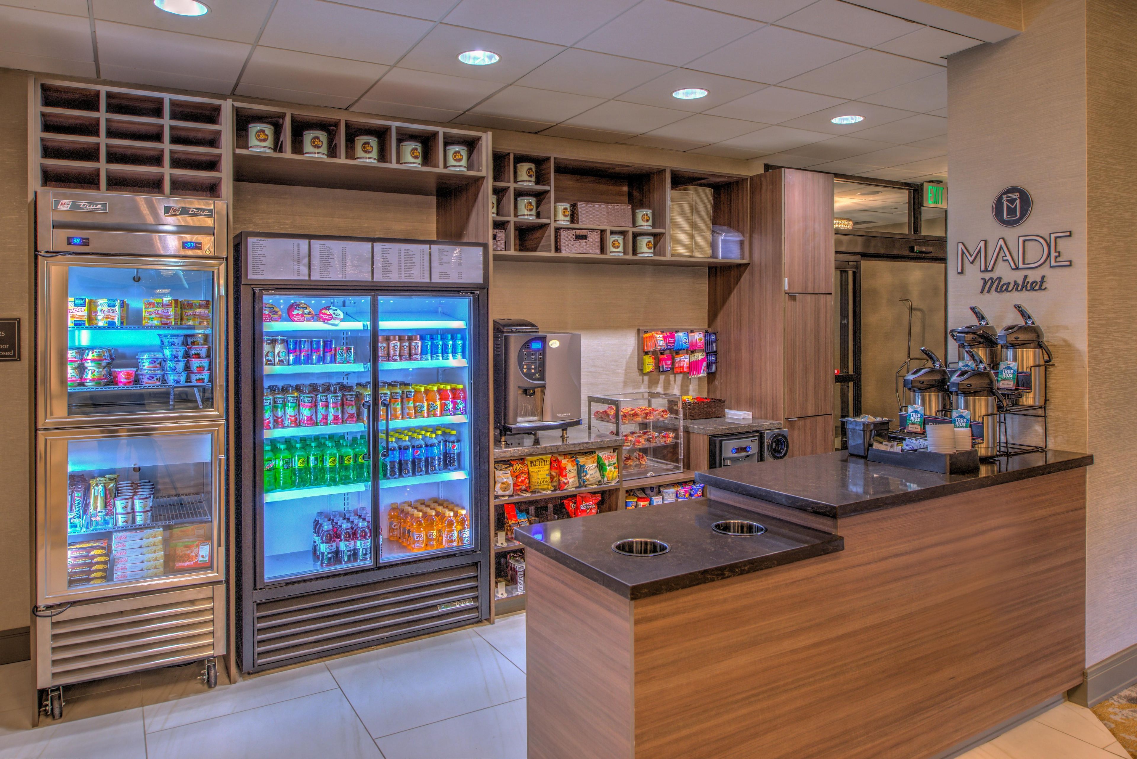 A self-service beverage station with refrigerated drink dispensers and a coffee machine.