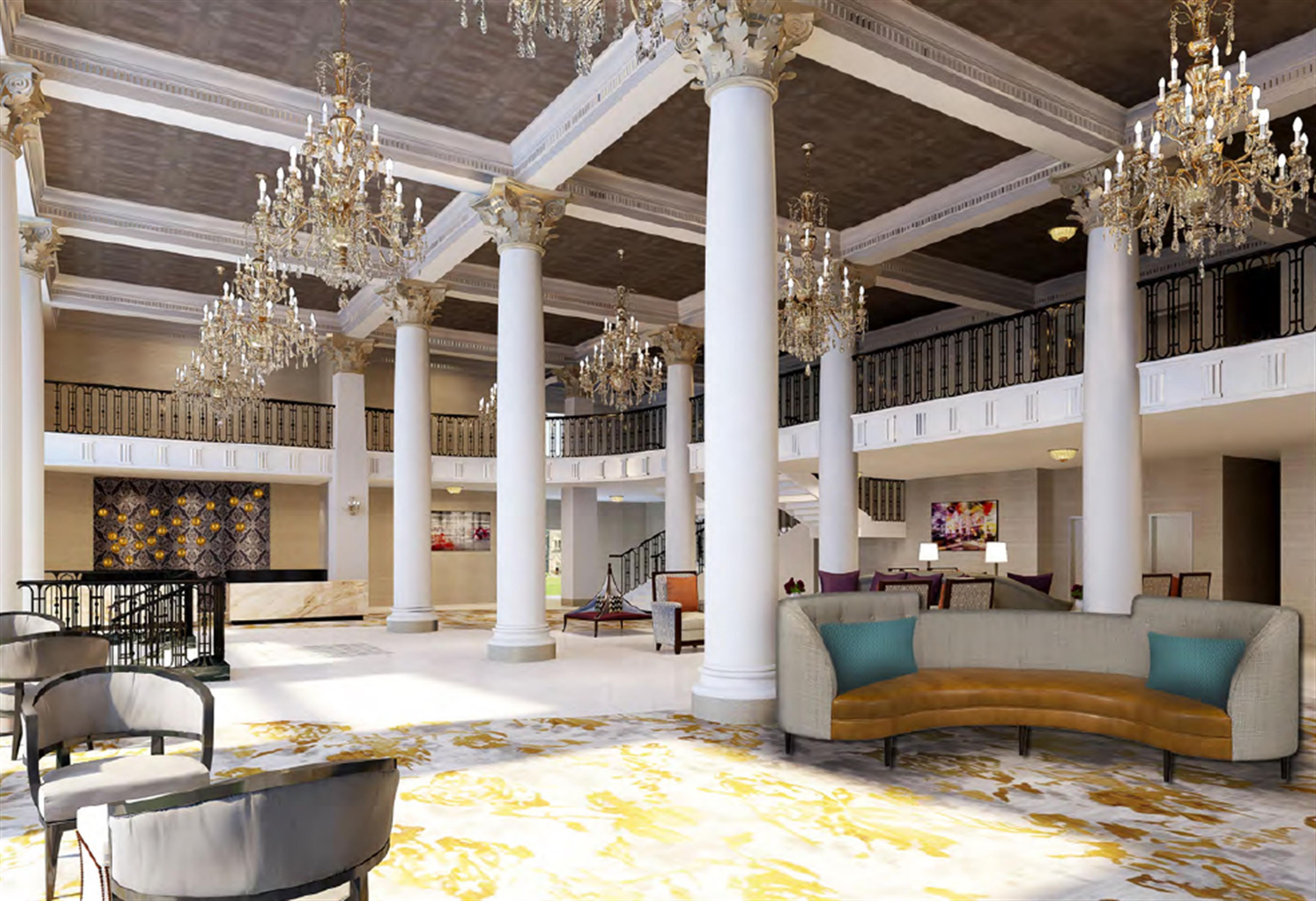 Un vestíbulo amplio con techos altos, candelabros ornamentales y una zona de estar central con un sofá curvo.