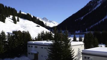 A snow-covered mountain landscape with a building in the foreground.