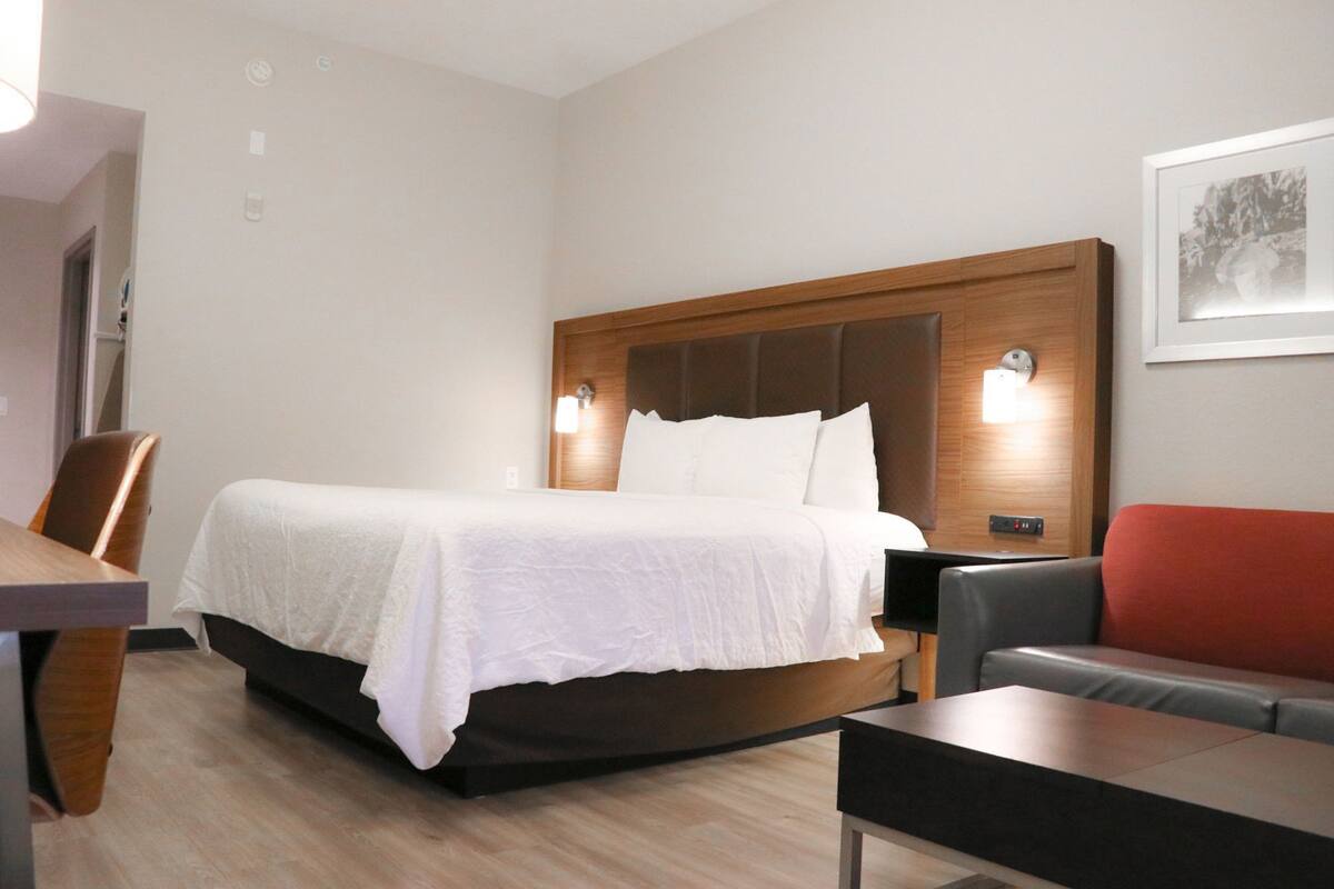 Une chambre d’hôtel avec un lit, un bureau, une chaise et un canapé.